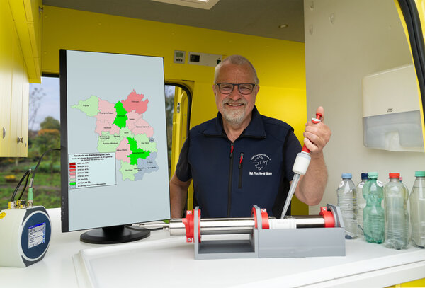 Harald Guelzow untersucht eine Brunnenwasserprobe