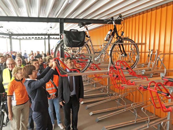 Infrastrukturministerin Kathrin Schneider und Bürgermeister Alexander Laesicke demonstrieren das »Doppelstockparksystem« im neuen Oranienburger Fahrradparkhaus am Bahnhof.