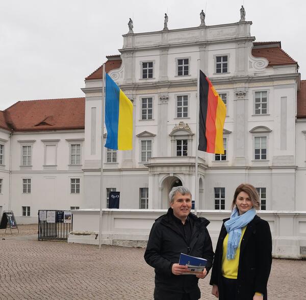 Bürgermeister Alexander Laesicke und Ilona Safyanenko, Ansprechpartnerin für ukrainische Flüchtlinge in der Stadtverwaltung, haben vor dem Schloss die Ukraine-Flagge gehisst.